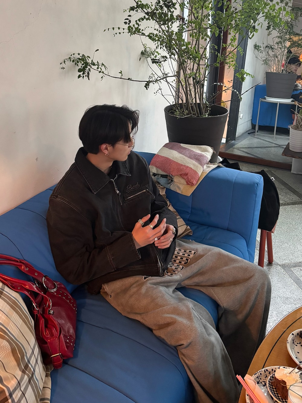 ブラック系のデニムジャケット、レッド系のバッグ、その他のTシャツ/カットソーを着用したメンズの冬コーディネートの2枚目の写真