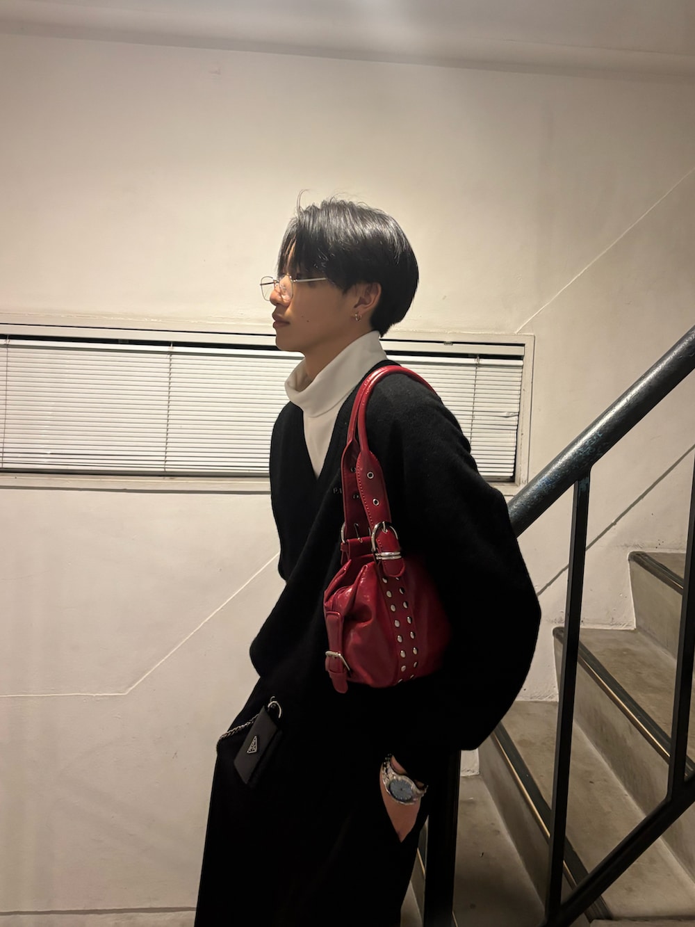 ブラック系のニット/セーター、ホワイト系のTシャツ/カットソー、レッド系のバッグを着用したメンズの冬コーディネートの3枚目の写真