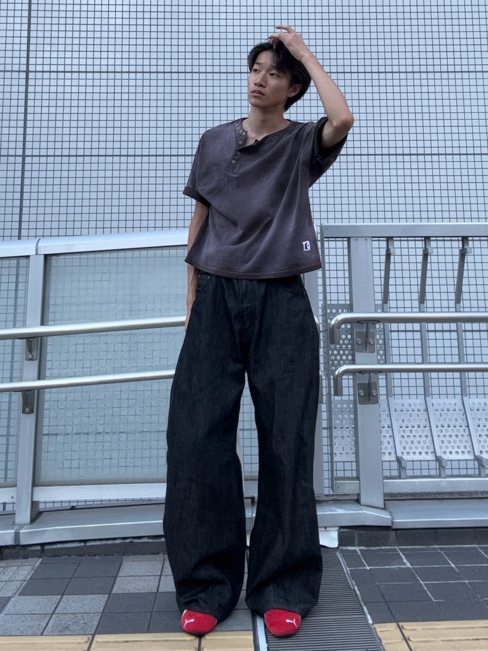 ブラウン系のTシャツ/カットソー、ブラック系のデニムパンツ、レッド系のスニーカーを着用したメンズの秋コーディネートの2枚目の写真