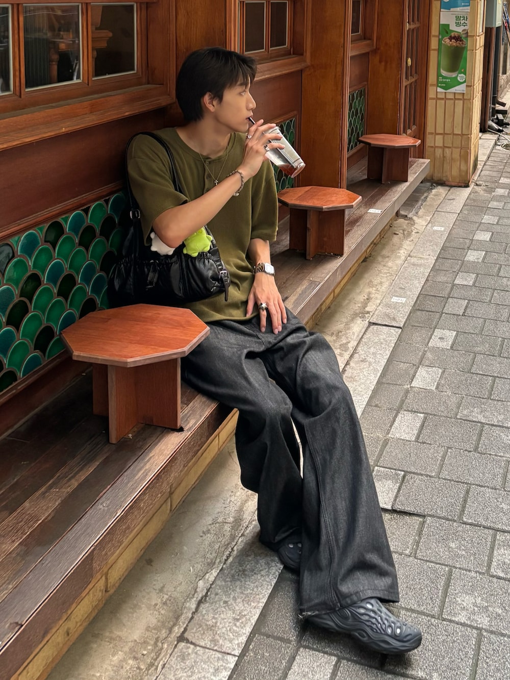 グリーン系のTシャツ/カットソー、ブラック系のデニムパンツ、ブラック系のサンダルを着用したメンズの夏コーディネートの2枚目の写真