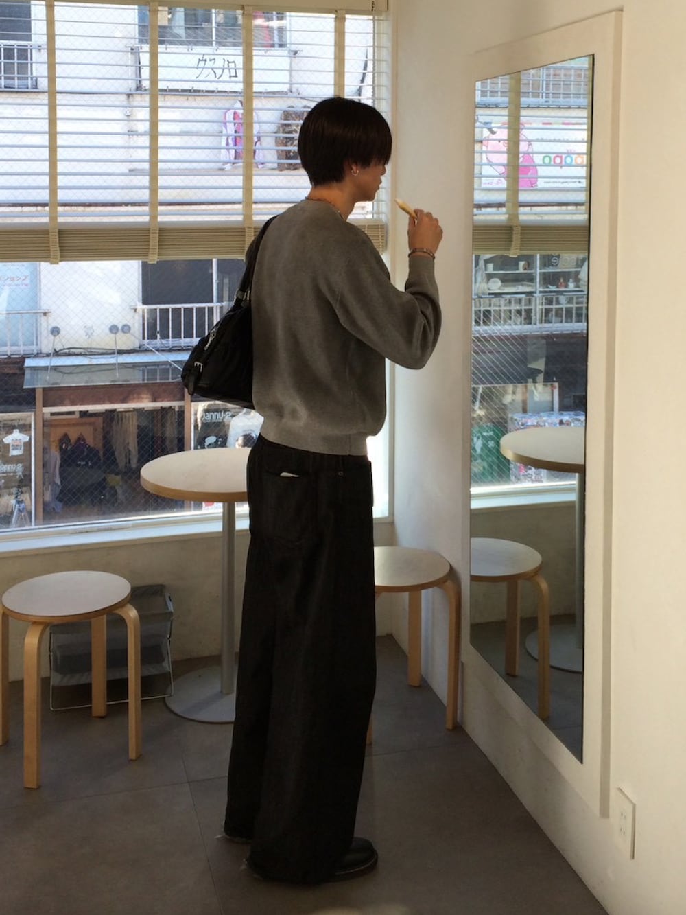 グレー系のニット/セーター、ブラック系のデニムパンツ、ブラック系のドレスシューズを着用したメンズの冬コーディネートの2枚目の写真