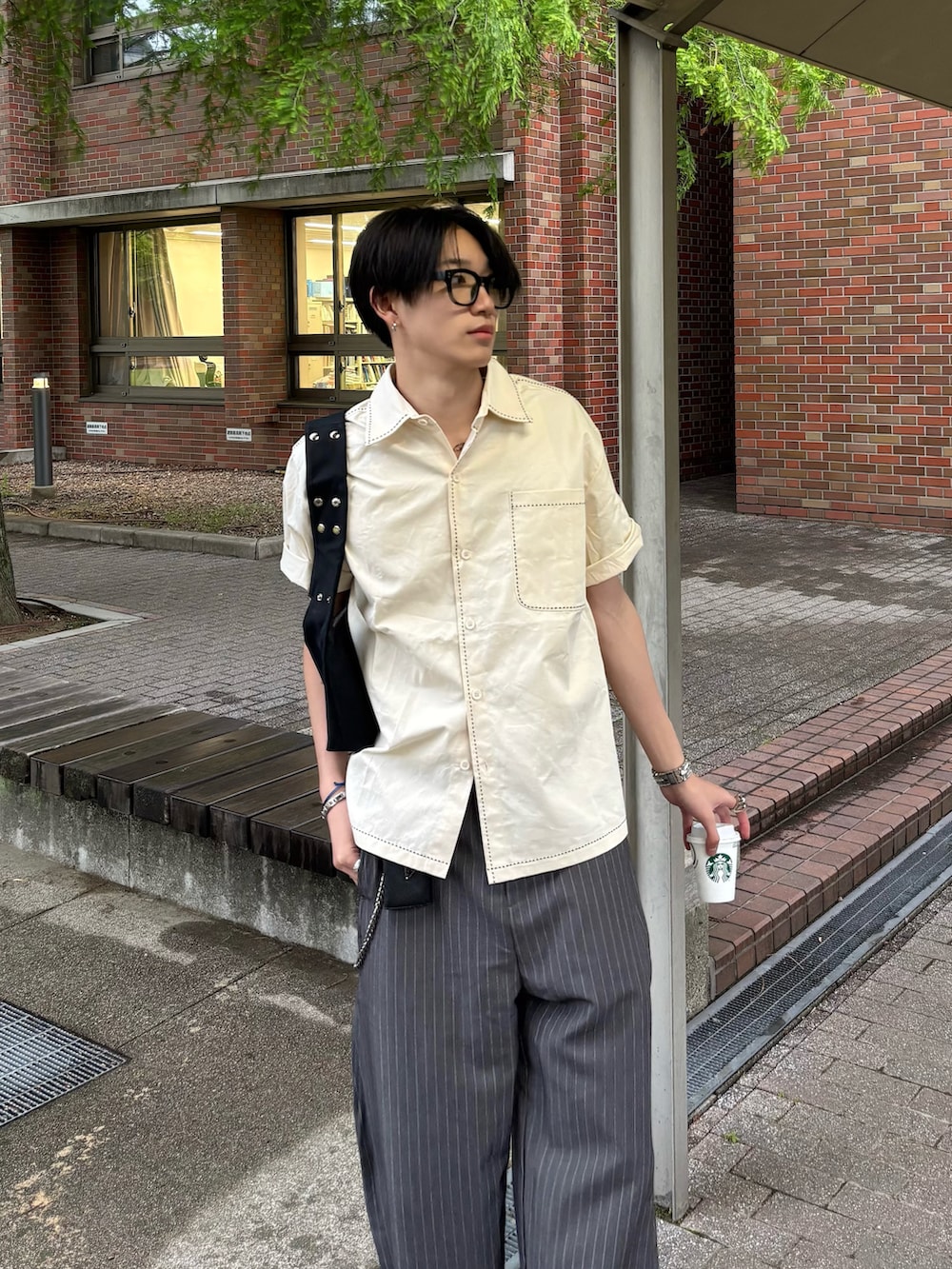 ホワイト系のシャツ/ブラウス、グレー系のスラックス、ブラック系のスニーカーを着用したメンズの春コーディネートの2枚目の写真
