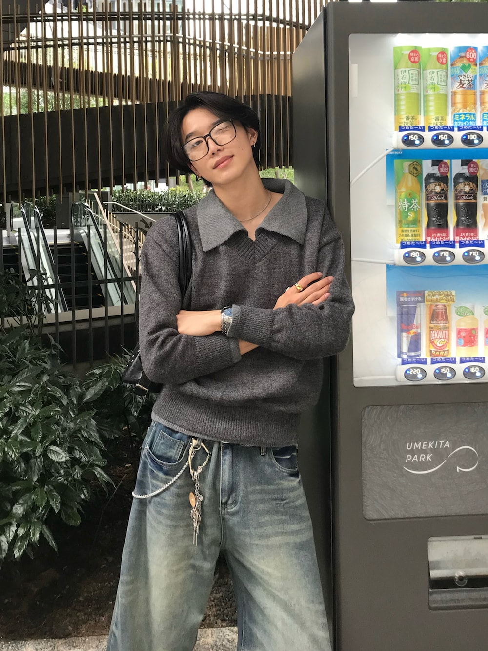 ブルー系のデニムパンツ、ブラック系のスニーカー、グレー系のニット/セーターを着用したメンズの秋コーディネートの4枚目の写真