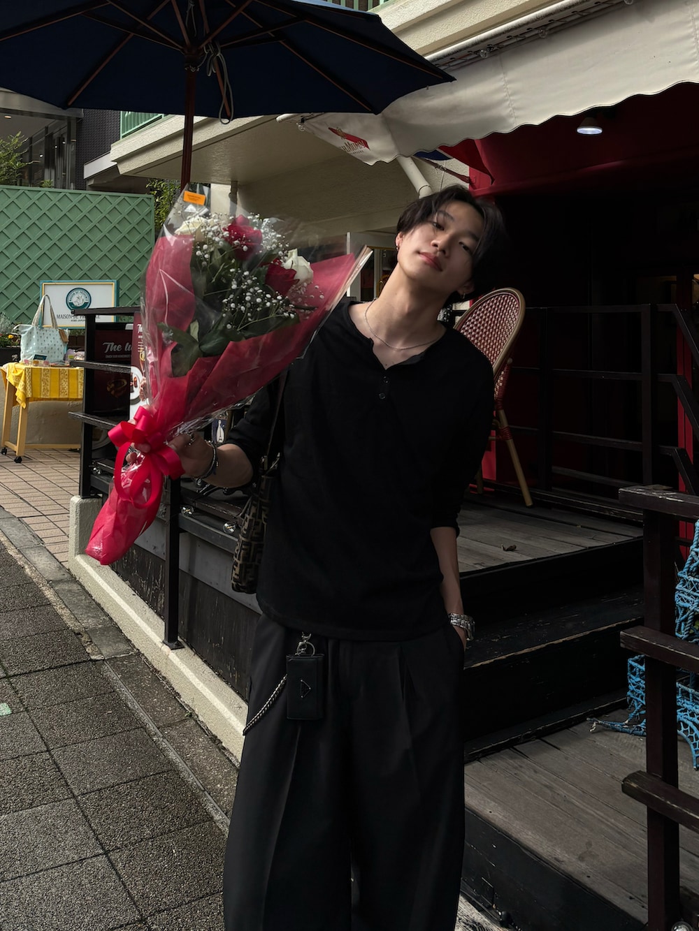 ブラック系のTシャツ/カットソー、ブラック系のスラックス、ブラック系のスニーカーを着用したメンズの夏コーディネートの3枚目の写真