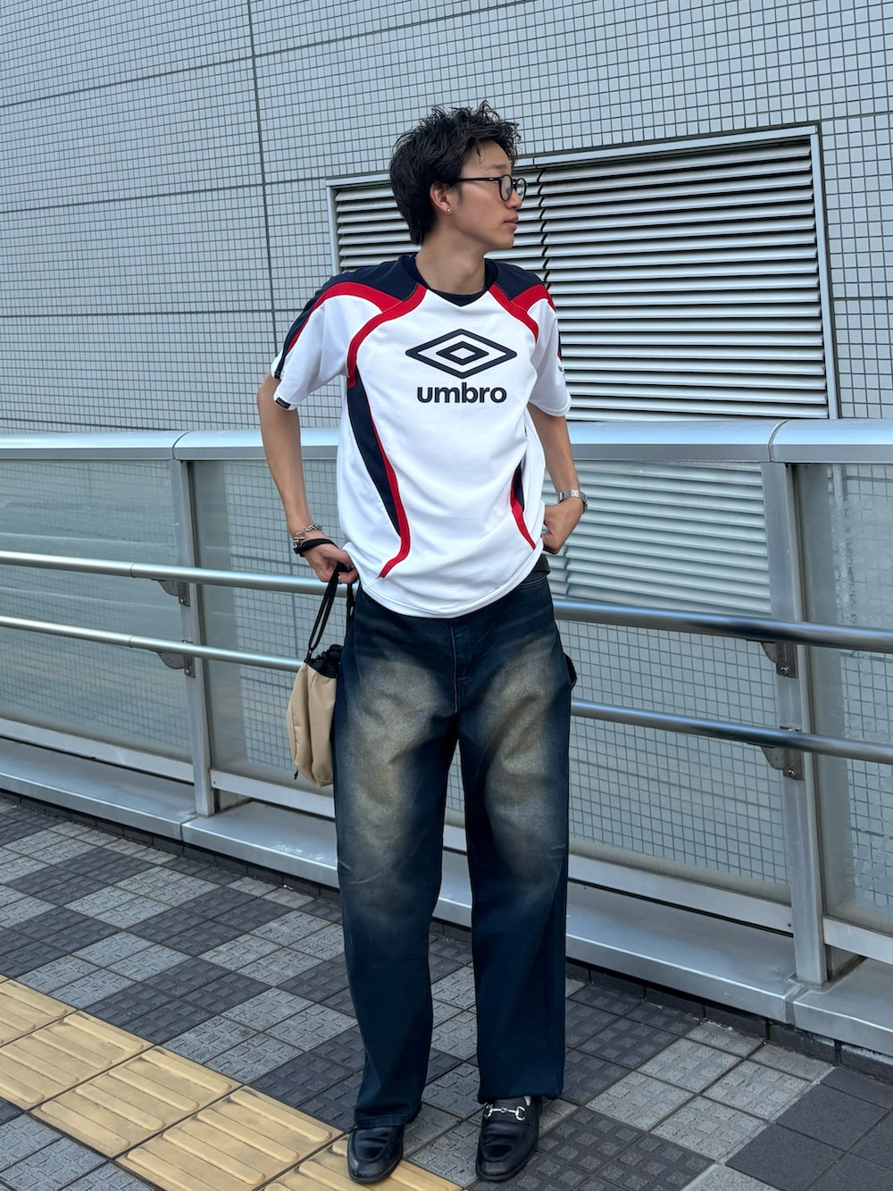 ホワイト系のTシャツ/カットソー、ベージュ系のハンドバッグ、ブルー系のデニムパンツを着用したメンズの夏コーディネートの2枚目の写真