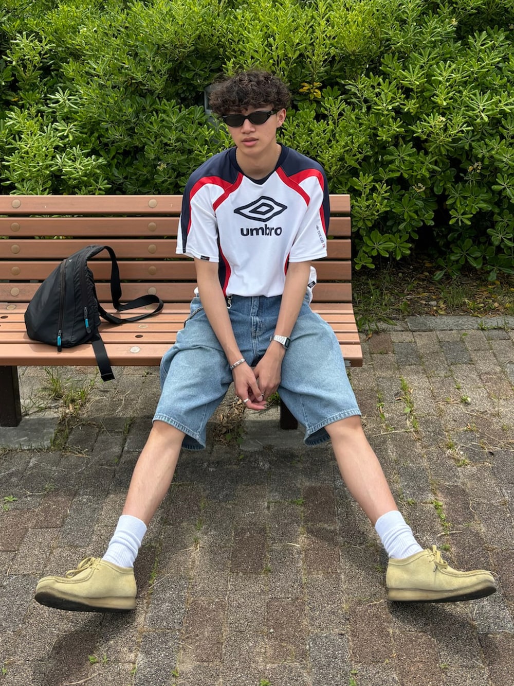 ホワイト系のTシャツ/カットソー、ブルー系のデニムパンツ、ベージュ系のブーツを着用したメンズの夏コーディネートの2枚目の写真