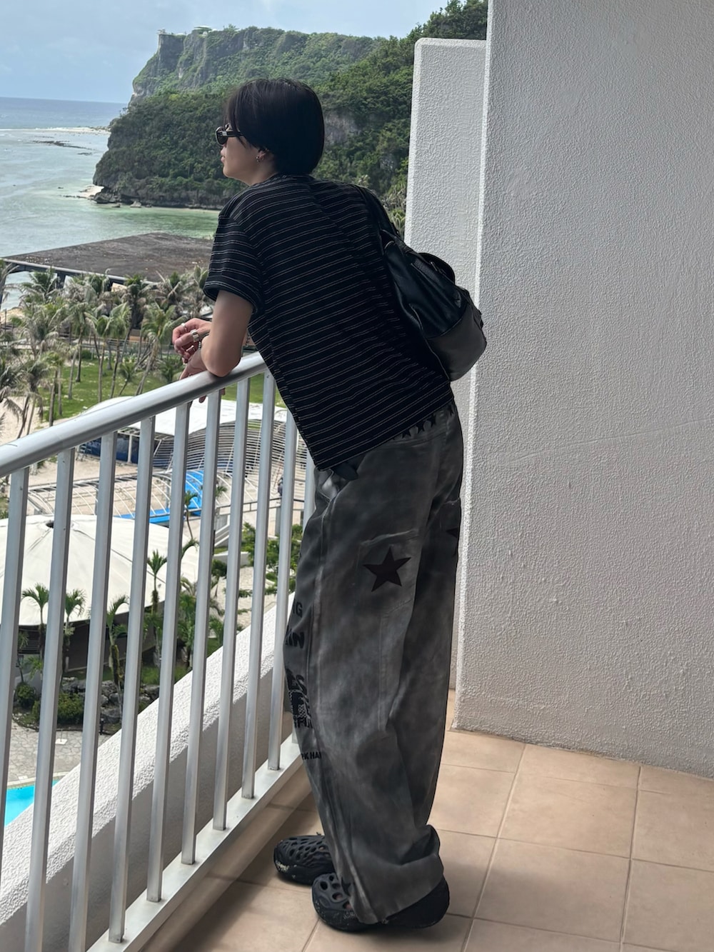 ブラック系のTシャツ/カットソー、ホワイト系のデニムパンツ、ブラック系のサンダルを着用したメンズの夏コーディネートの4枚目の写真
