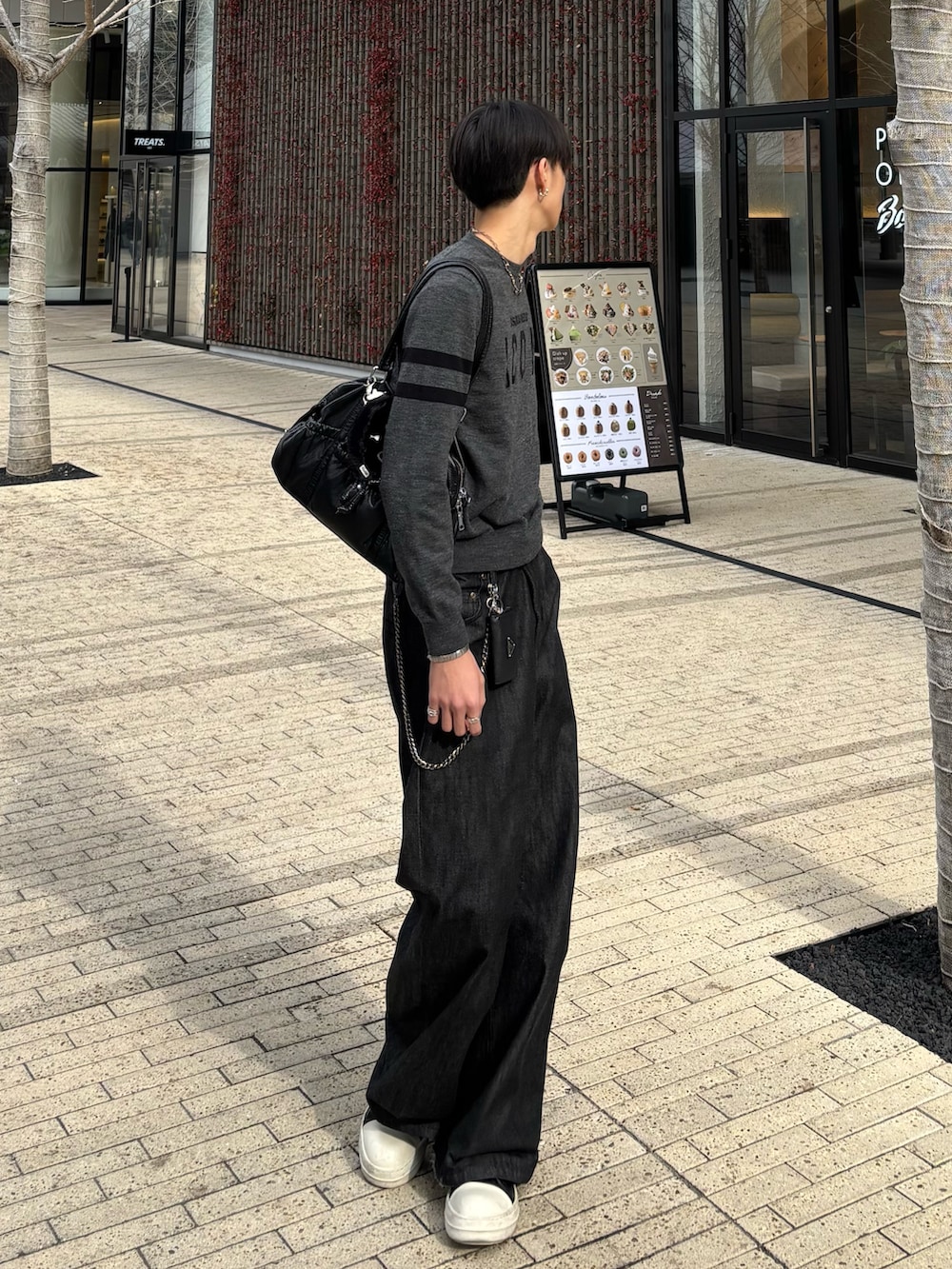 グレー系のニット/セーター、ブラック系のデニムパンツ、ブラック系のスニーカーを着用したメンズの冬コーディネートの3枚目の写真