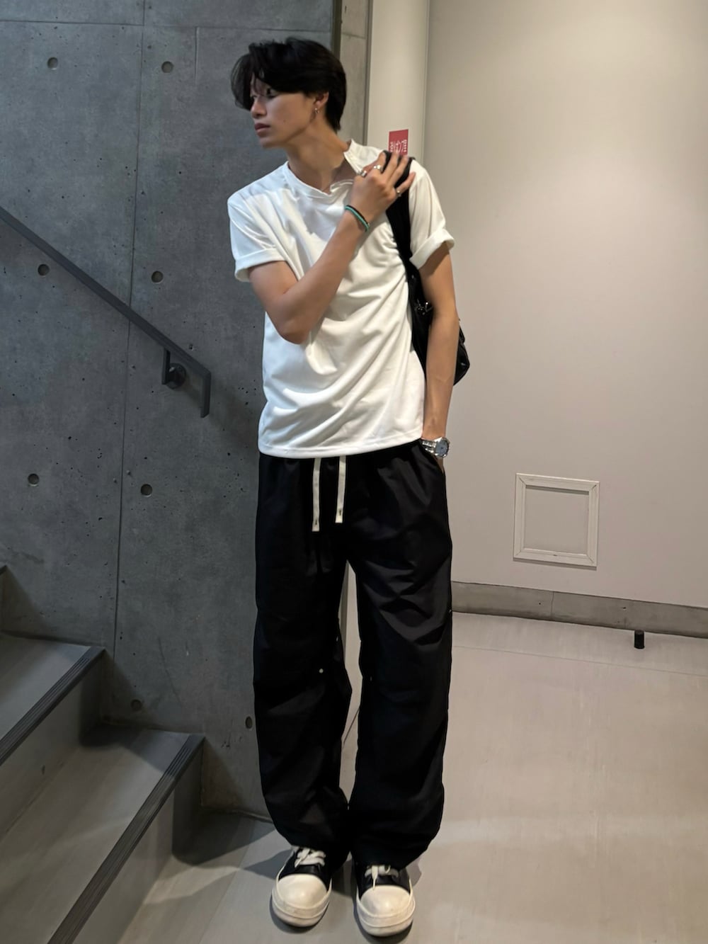 ホワイト系のTシャツ/カットソー、ブラウン系のショルダーバッグ、ブラック系のパンツを着用したメンズの夏コーディネートの2枚目の写真