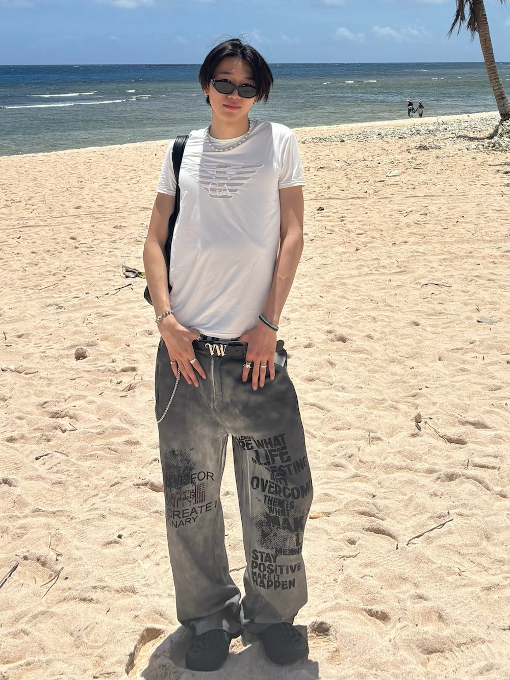 ホワイト系のデニムパンツ、ブラック系のサンダル、ホワイト系のラッシュガードを着用したメンズの夏コーディネートの2枚目の写真