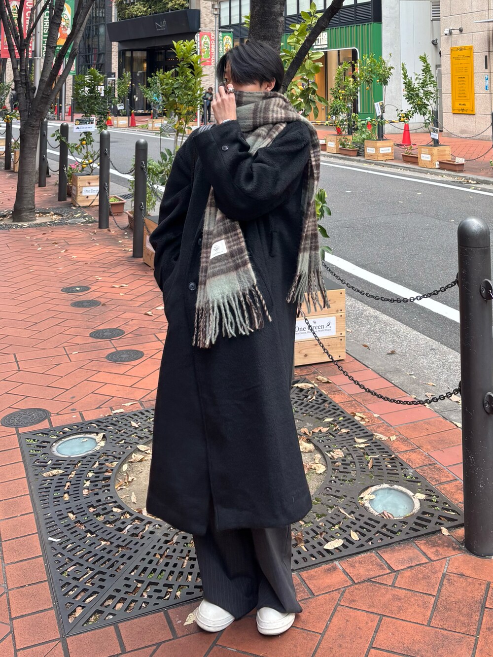 ブラック系のチェスターコート、ブラック系のスニーカー、グレー系のスラックスを着用したメンズの冬コーディネートの2枚目の写真