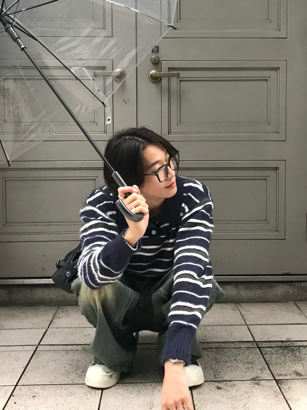 ブルー系のニット/セーター、ブルー系のデニムパンツ、ブラック系のスニーカーを着用したメンズの秋コーディネートの3枚目の写真