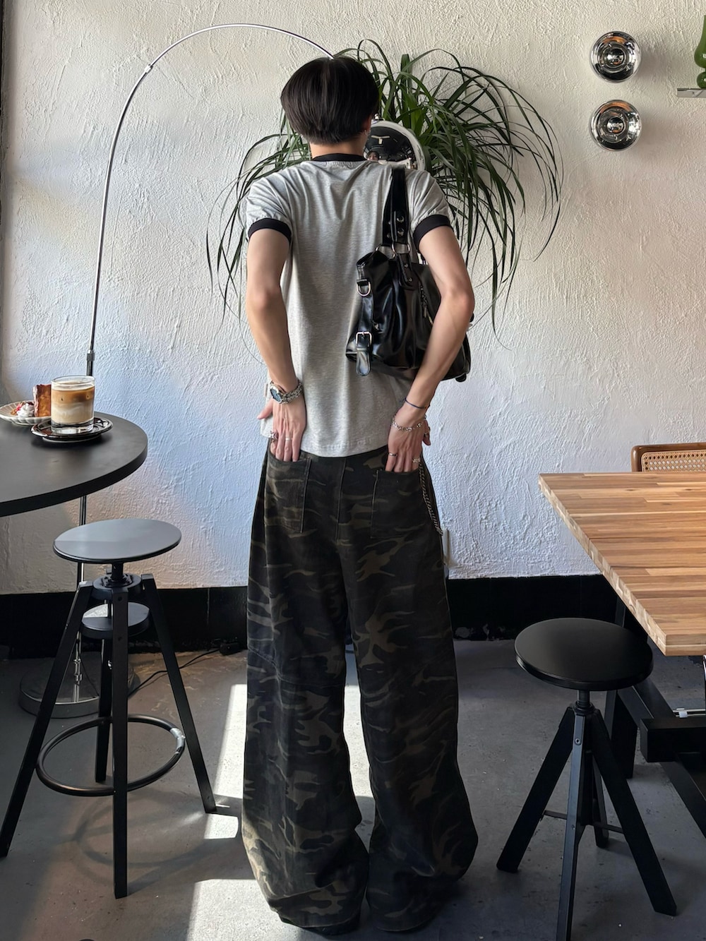 グレー系のTシャツ/カットソー、ブラック系のショルダーバッグ、その他のデニムパンツを着用したメンズの春コーディネートの3枚目の写真
