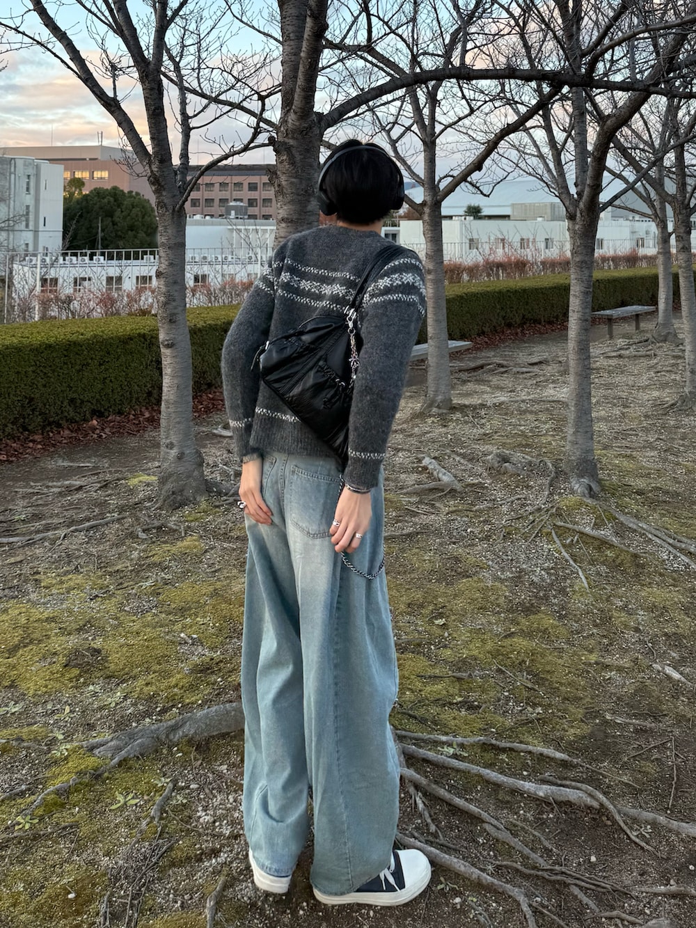 グレー系のニット/セーター、ブルー系のデニムパンツ、ブラック系のスニーカーを着用したメンズの冬コーディネートの3枚目の写真