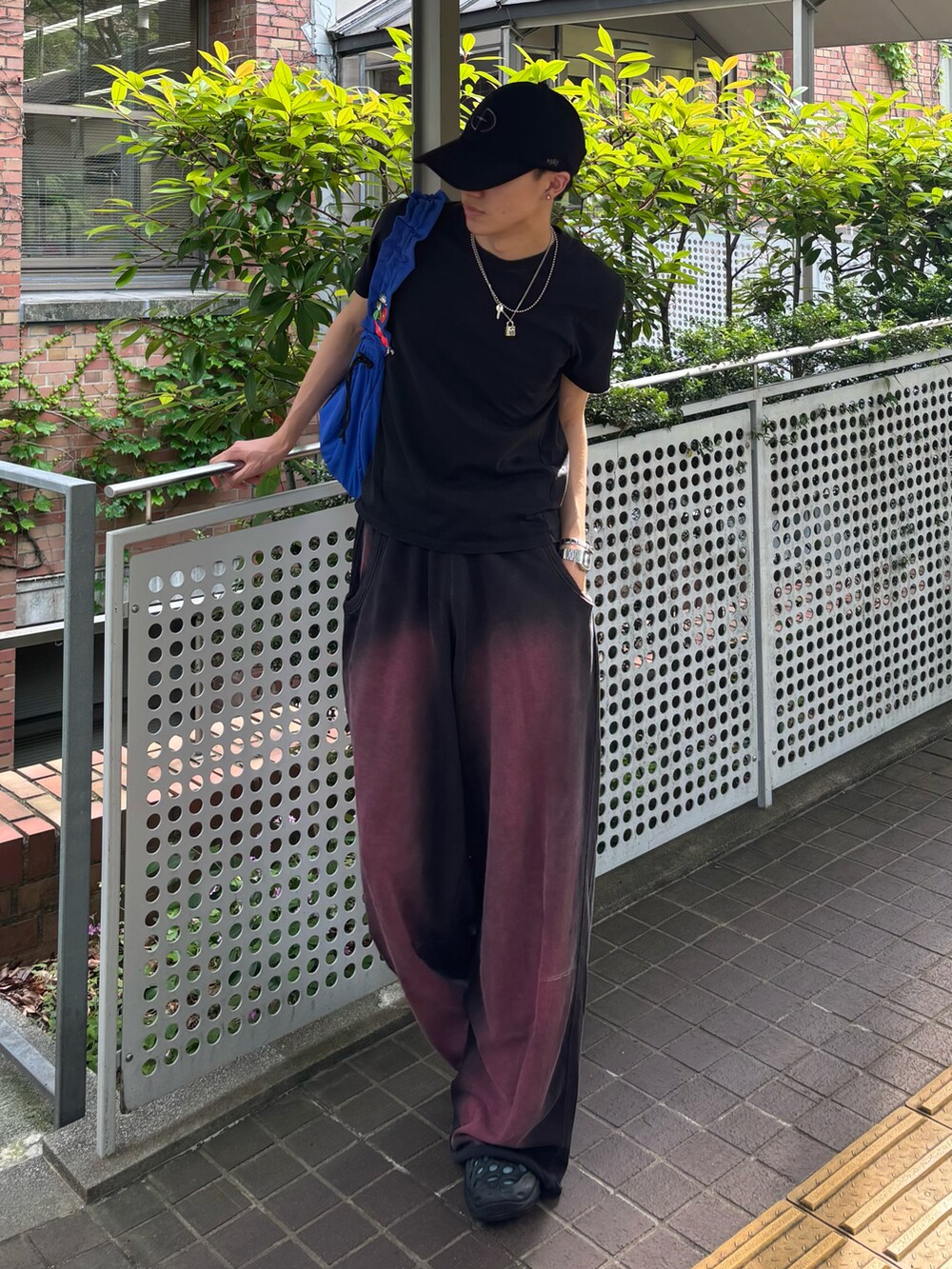 ブルー系のトートバッグ、ブラック系のスウェットパンツ、ブラック系のTシャツ/カットソーを着用したメンズの夏コーディネートの2枚目の写真