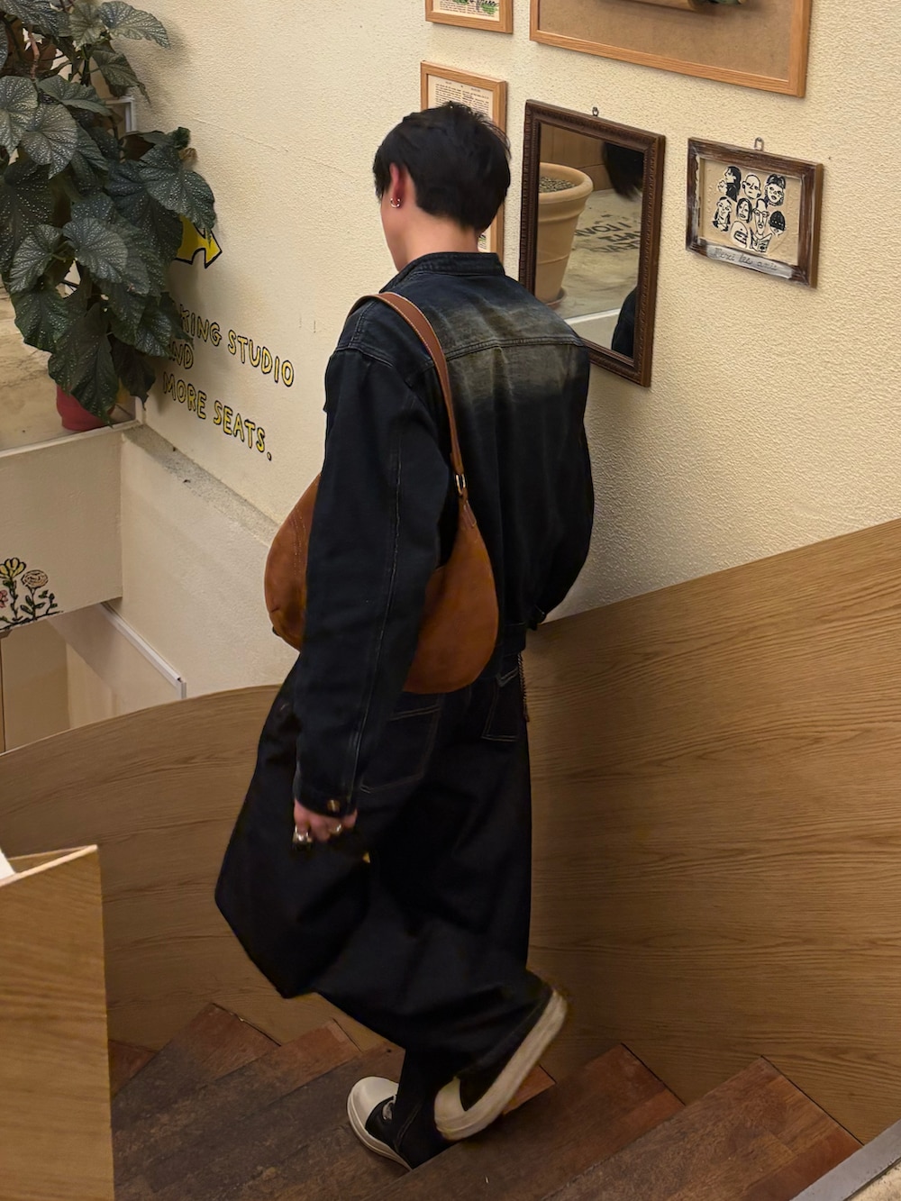 ブルー系のデニムジャケット、ブラウン系のショルダーバッグ、ブルー系のデニムパンツを着用したメンズの冬コーディネートの3枚目の写真