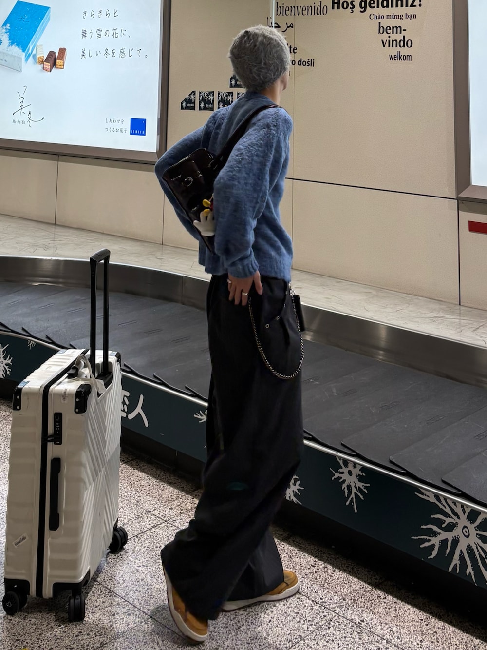 ブルー系のニット/セーター、ブラウン系のショルダーバッグ、グレー系のスラックスを着用したメンズの秋コーディネートの2枚目の写真