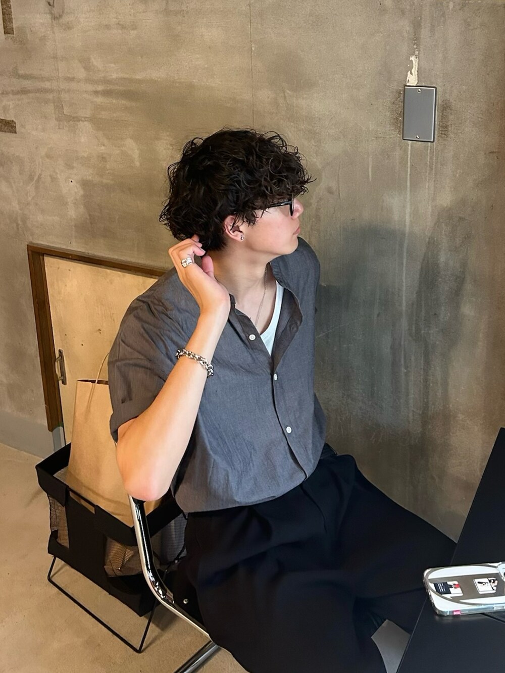 グレー系のシャツ/ブラウス、グリーン系のトートバッグ、ブラック系のスラックスを着用したメンズの春コーディネートの4枚目の写真