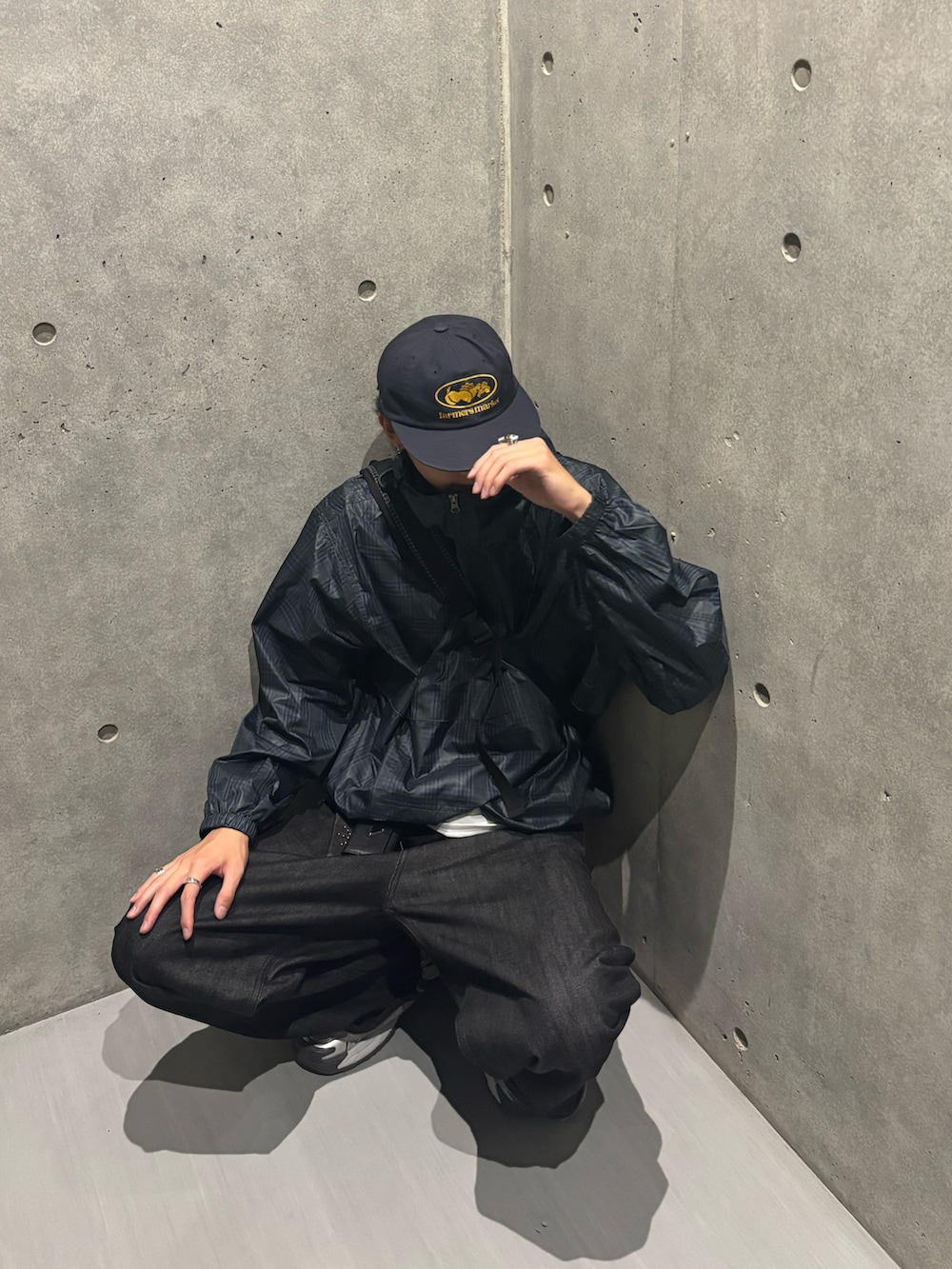 ブルー系のパーカー、ブラック系のデニムパンツ、ホワイト系のスニーカーを着用したメンズの秋コーディネートの2枚目の写真