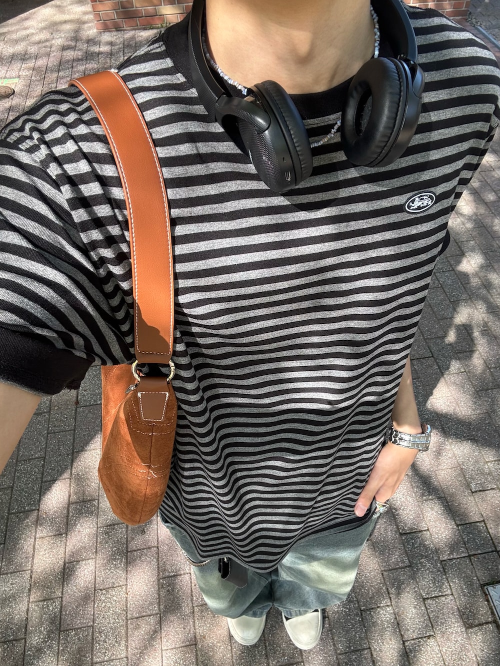 ブラック系のTシャツ/カットソー、ブルー系のデニムパンツ、ブラック系のスニーカーを着用したメンズの春コーディネートの4枚目の写真