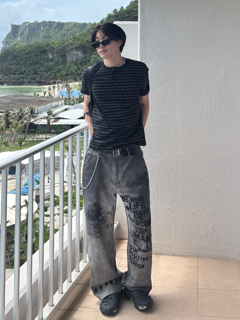 ブラック系のTシャツ/カットソー、ホワイト系のデニムパンツ、ブラック系のサンダルを着用したメンズの夏コーディネートの2枚目の写真