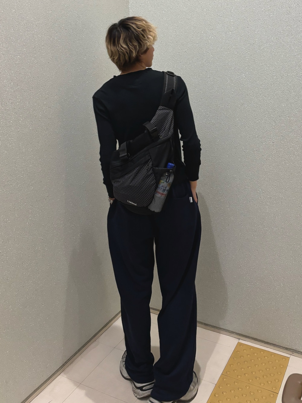 ブラック系のTシャツ/カットソー、ブラック系のショルダーバッグ、ブルー系のスウェットパンツを着用したメンズの春コーディネートの3枚目の写真
