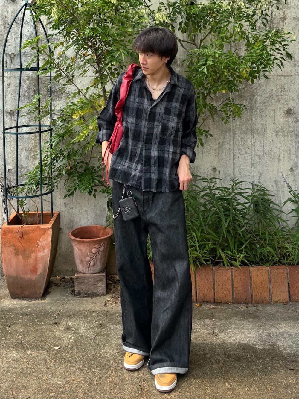 ブラック系のシャツ/ブラウス、ブラック系のデニムパンツ、レッド系のショルダーバッグを着用したメンズの秋コーディネートの2枚目の写真