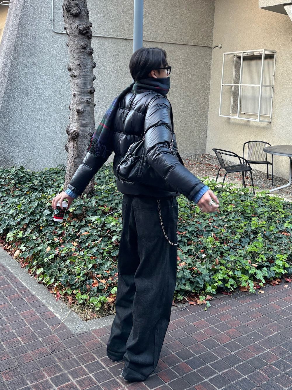 ブルー系のニット/セーター、ブラック系のデニムパンツ、ブラック系のスニーカーを着用したメンズの冬コーディネートの2枚目の写真