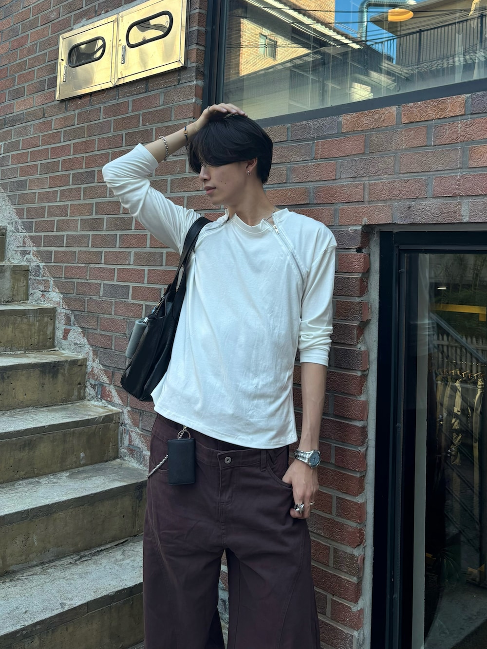 ホワイト系のTシャツ/カットソー、ブラウン系のチノパンツ、ブラック系のスニーカーを着用したメンズの夏コーディネートの4枚目の写真