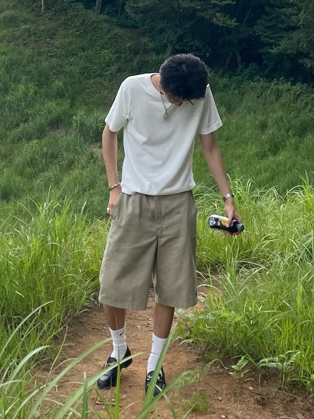 ホワイト系のTシャツ/カットソー、ベージュ系のチノパンツ、ブラック系のローファーを着用したメンズの夏コーディネートの2枚目の写真