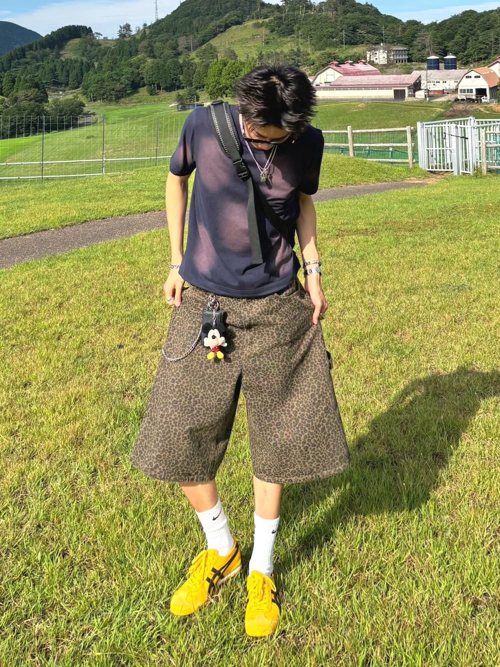 ブルー系のTシャツ/カットソー、ブラウン系のデニムパンツ、イエロー系のスニーカーを着用したメンズの夏コーディネートの2枚目の写真