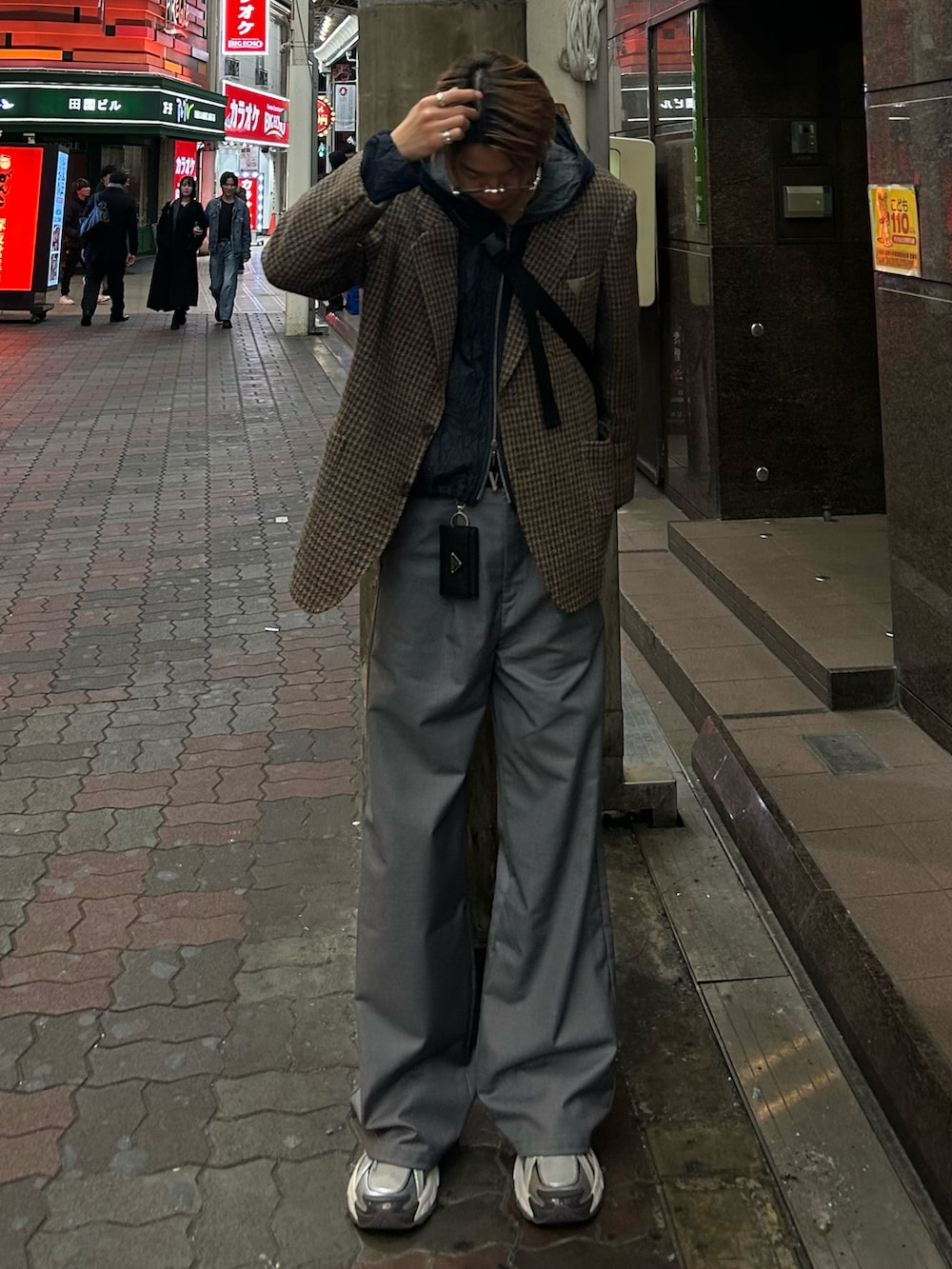 ブルー系のパーカー、ブラウン系のテーラードジャケット、グレー系のスラックスを着用したメンズの春コーディネートの3枚目の写真