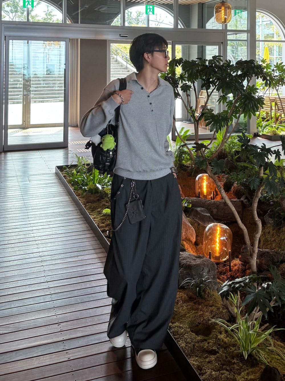 グレー系のポロシャツ、グレー系のスラックス、ブラック系のトートバッグを着用したメンズの秋コーディネートの3枚目の写真