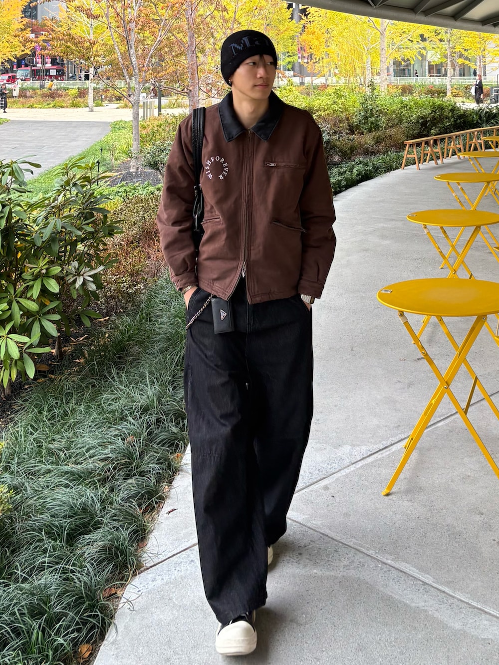 ブラウン系のブルゾン、ブラック系のデニムパンツ、ブラック系のスニーカーを着用したメンズの秋コーディネートの2枚目の写真