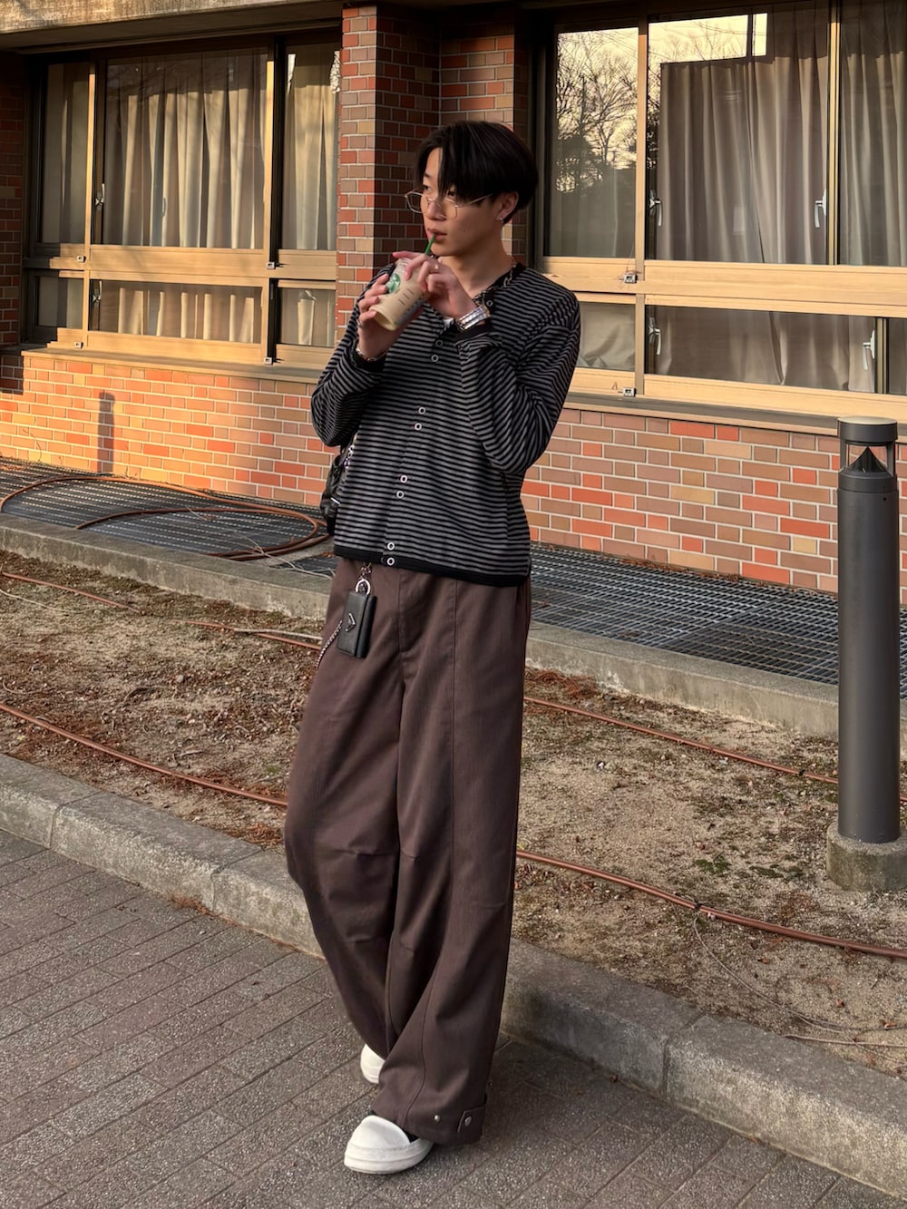 ブラック系のカーディガン/ボレロ、ブラウン系のスラックス、ブラック系のスニーカーを着用したメンズの冬コーディネートの2枚目の写真