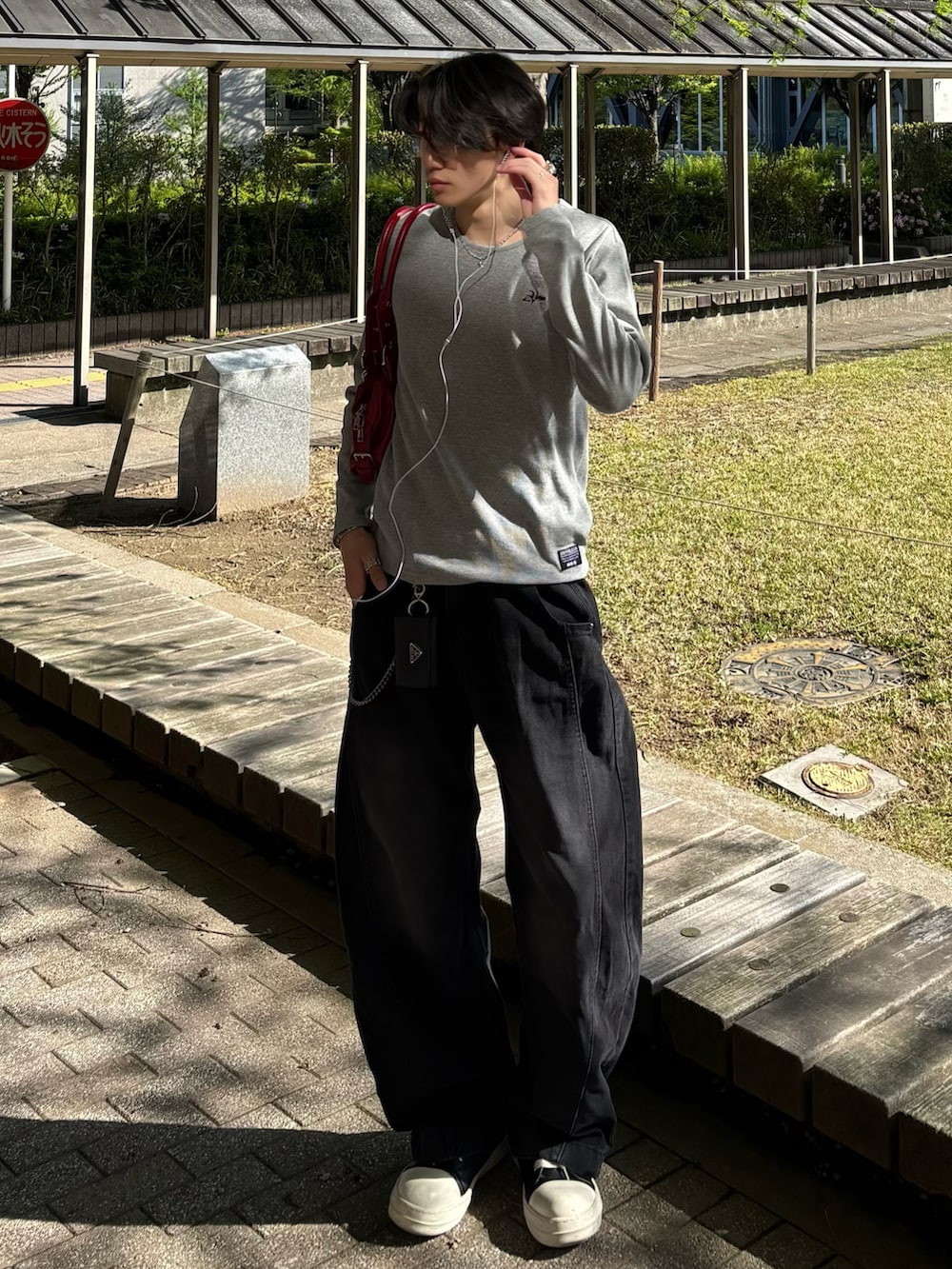 グレー系のTシャツ/カットソー、ブラック系のデニムパンツ、ブラック系のスニーカーを着用したメンズの春コーディネートの2枚目の写真