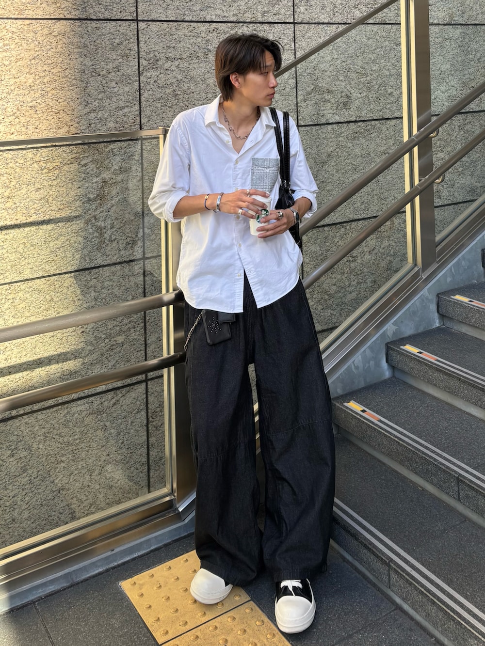 ホワイト系のシャツ/ブラウス、ブラック系のデニムパンツ、ブラック系のスニーカーを着用したメンズの秋コーディネートの2枚目の写真