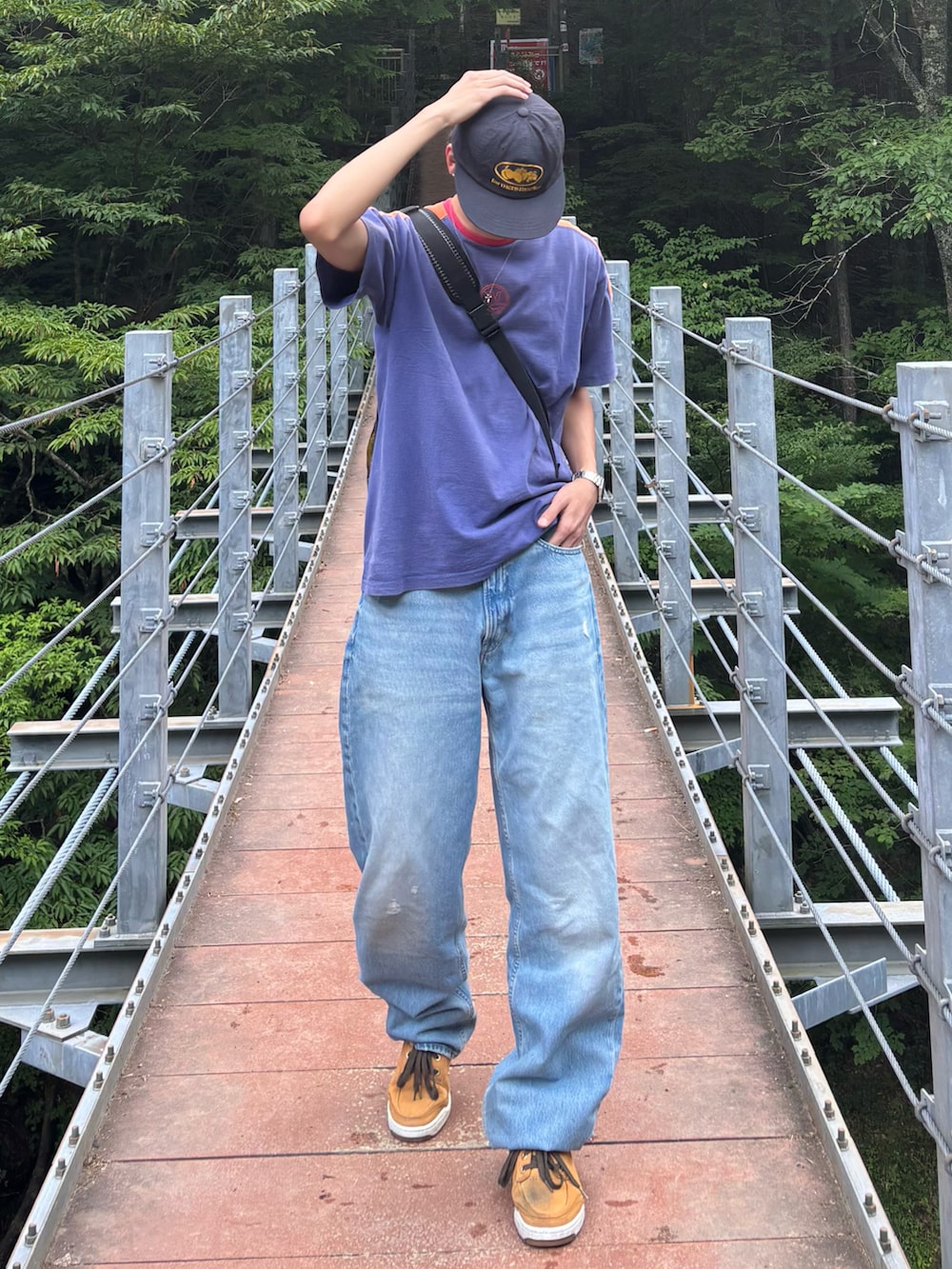 ブルー系のTシャツ/カットソー、ブルー系のデニムパンツ、ベージュ系のスニーカーを着用したメンズの夏コーディネートの2枚目の写真