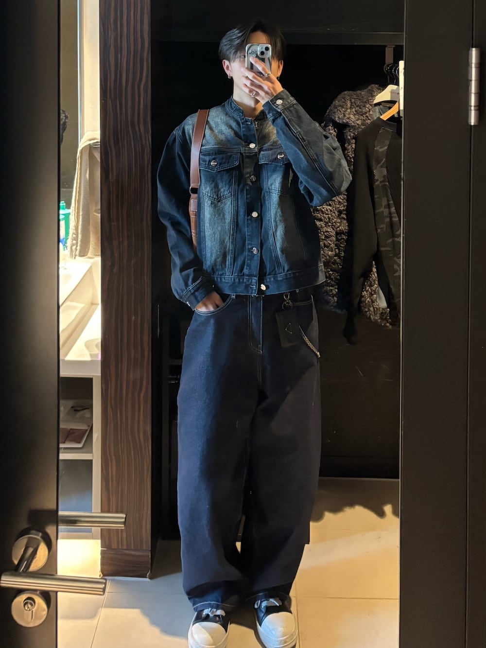 ブルー系のデニムジャケット、ブラウン系のショルダーバッグ、ブルー系のデニムパンツを着用したメンズの冬コーディネートの4枚目の写真