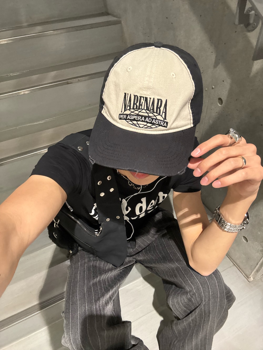 ブラック系のTシャツ/カットソー、ブラック系のショルダーバッグ、グレー系のスラックスを着用したメンズの春コーディネートの4枚目の写真