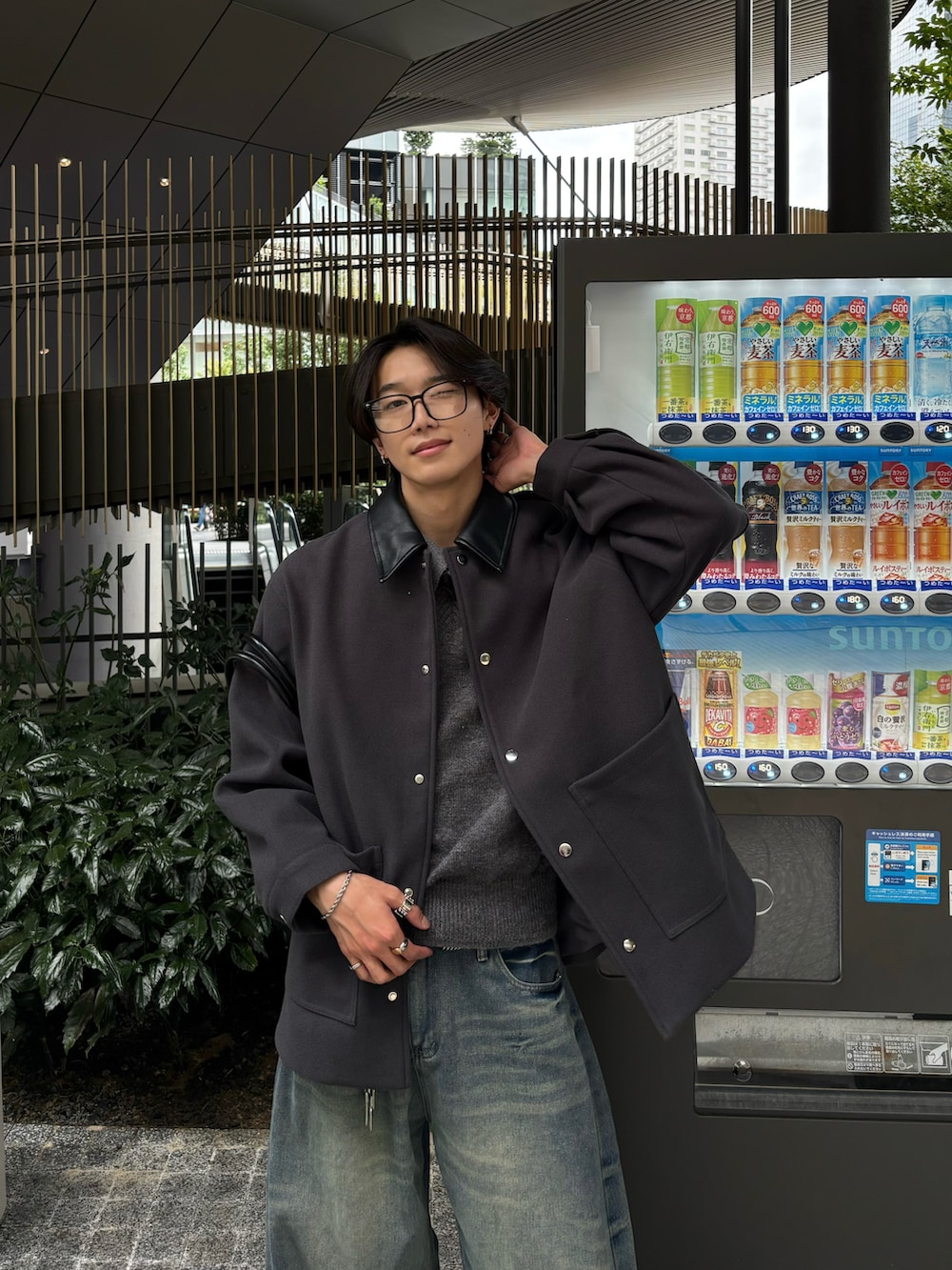 ブルー系のデニムパンツ、ブラック系のスニーカー、グレー系のステンカラーコートを着用したメンズの秋コーディネートの5枚目の写真
