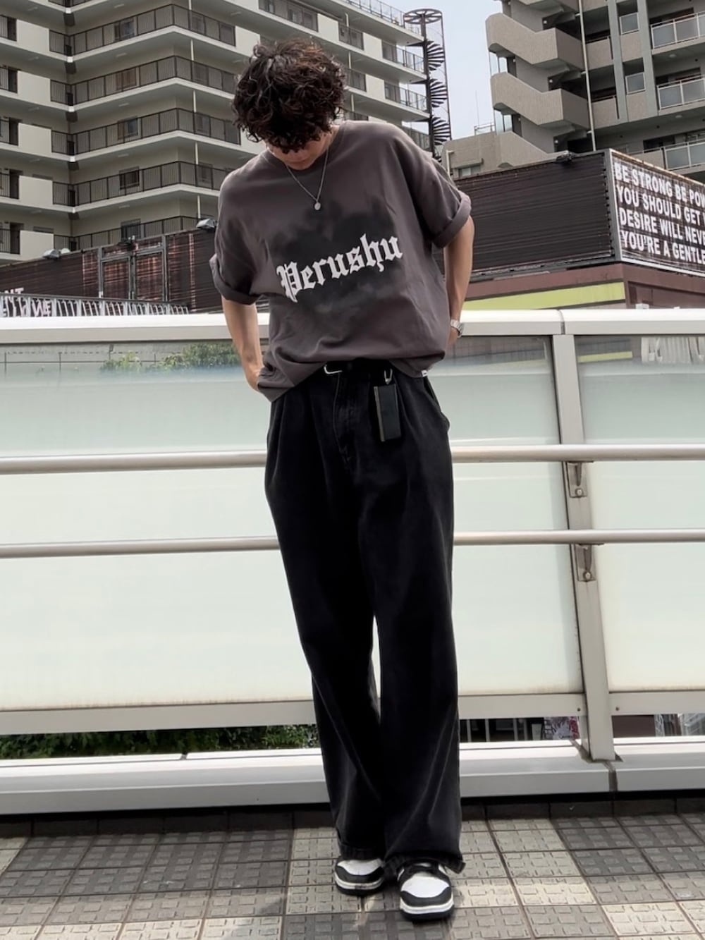 グレー系のTシャツ/カットソー、ブラック系のデニムパンツ、ホワイト系のスニーカーを着用したメンズの夏コーディネートの2枚目の写真