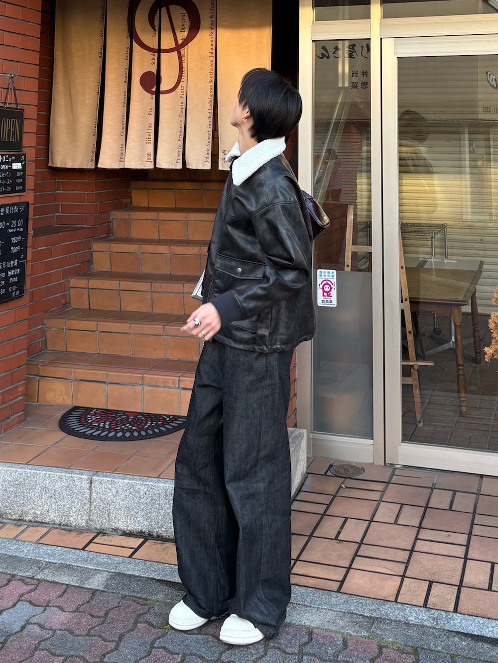 ブラック系のブルゾン、ブラウン系のショルダーバッグ、ブラック系のデニムパンツを着用したメンズの冬コーディネートの2枚目の写真