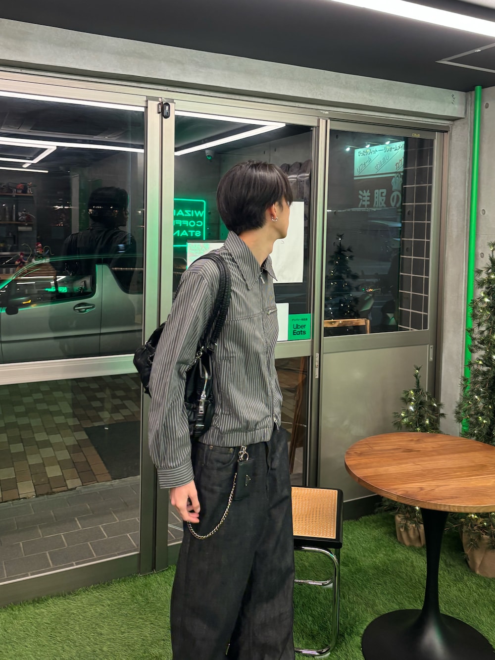 グレー系のブルゾン、ブラック系のデニムパンツ、ブラック系のスニーカーを着用したメンズの冬コーディネートの3枚目の写真