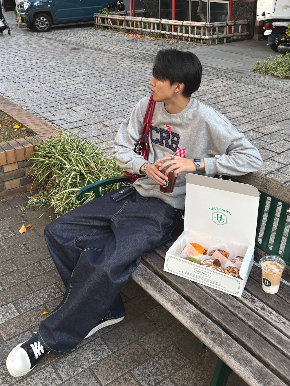 グレー系のスウェット、ブルー系のデニムパンツ、ブラック系のスニーカーを着用したメンズの秋コーディネートの3枚目の写真
