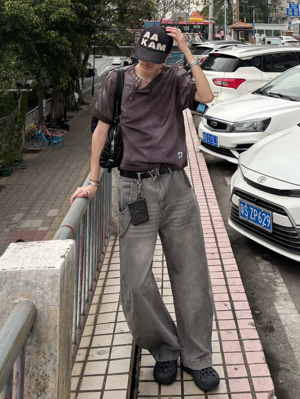 ブラウン系のTシャツ/カットソー、グレー系のデニムパンツ、ブラック系のサンダルを着用したメンズの春コーディネートの2枚目の写真