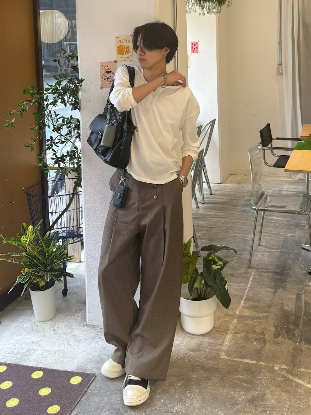 ホワイト系のTシャツ/カットソー、ブラウン系のスラックス、ブラック系のスニーカーを着用したメンズの夏コーディネートの2枚目の写真