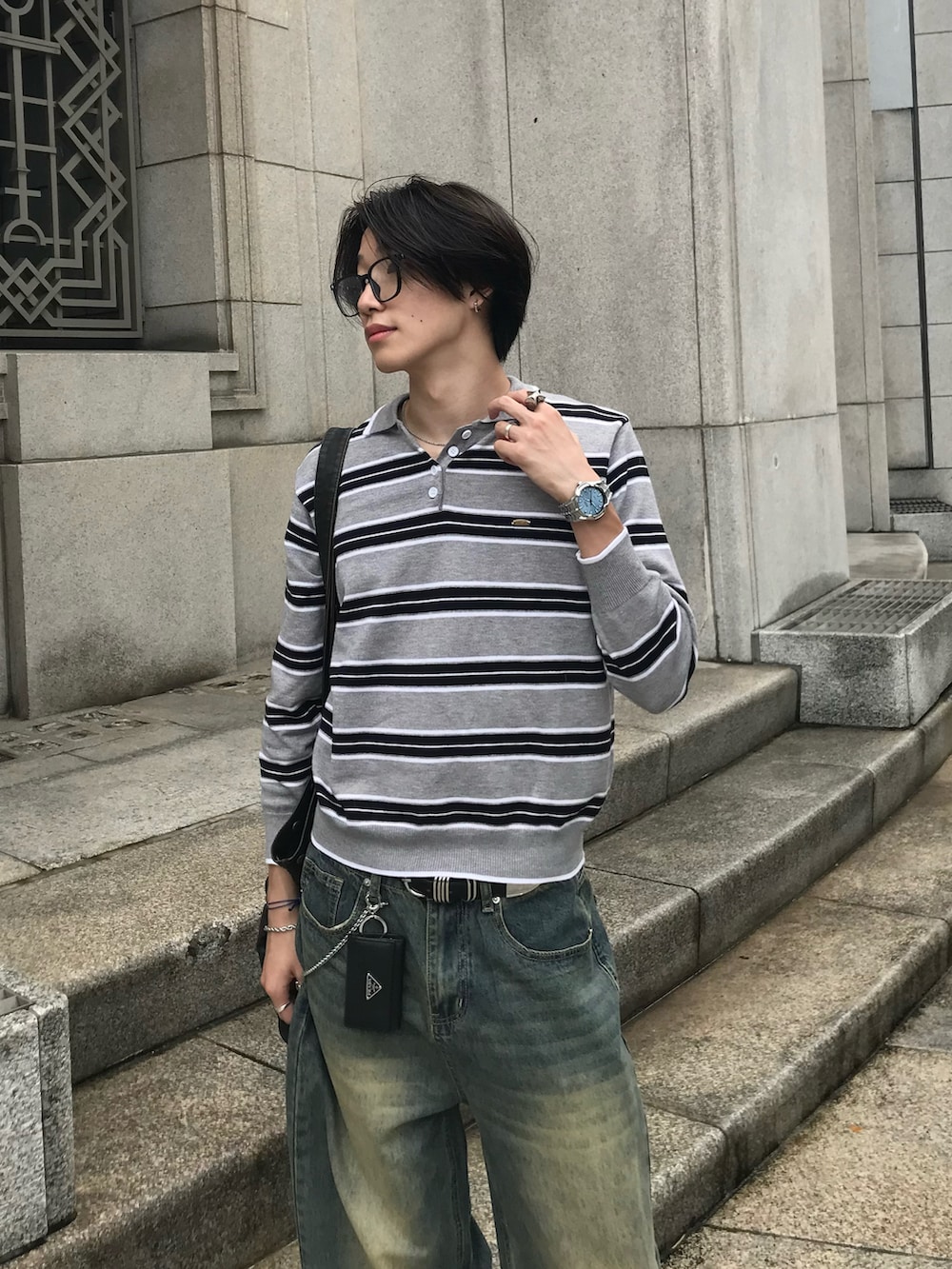 グレー系のニット/セーター、ブルー系のデニムパンツ、ブラック系のスニーカーを着用したメンズの秋コーディネートの3枚目の写真
