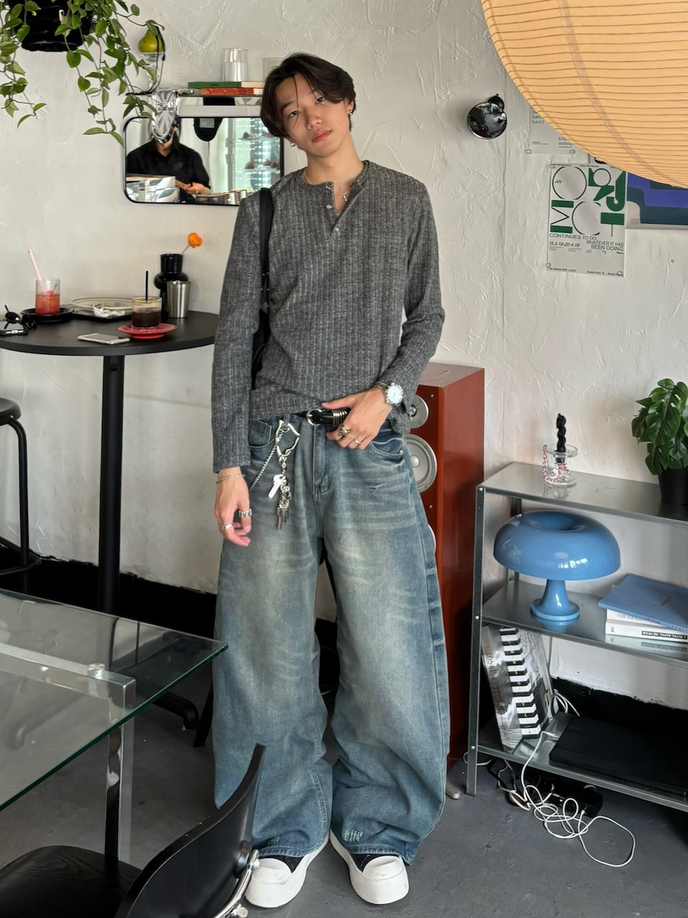 グレー系のTシャツ/カットソー、ブルー系のデニムパンツ、ブラック系のスニーカーを着用したメンズの秋コーディネートの2枚目の写真