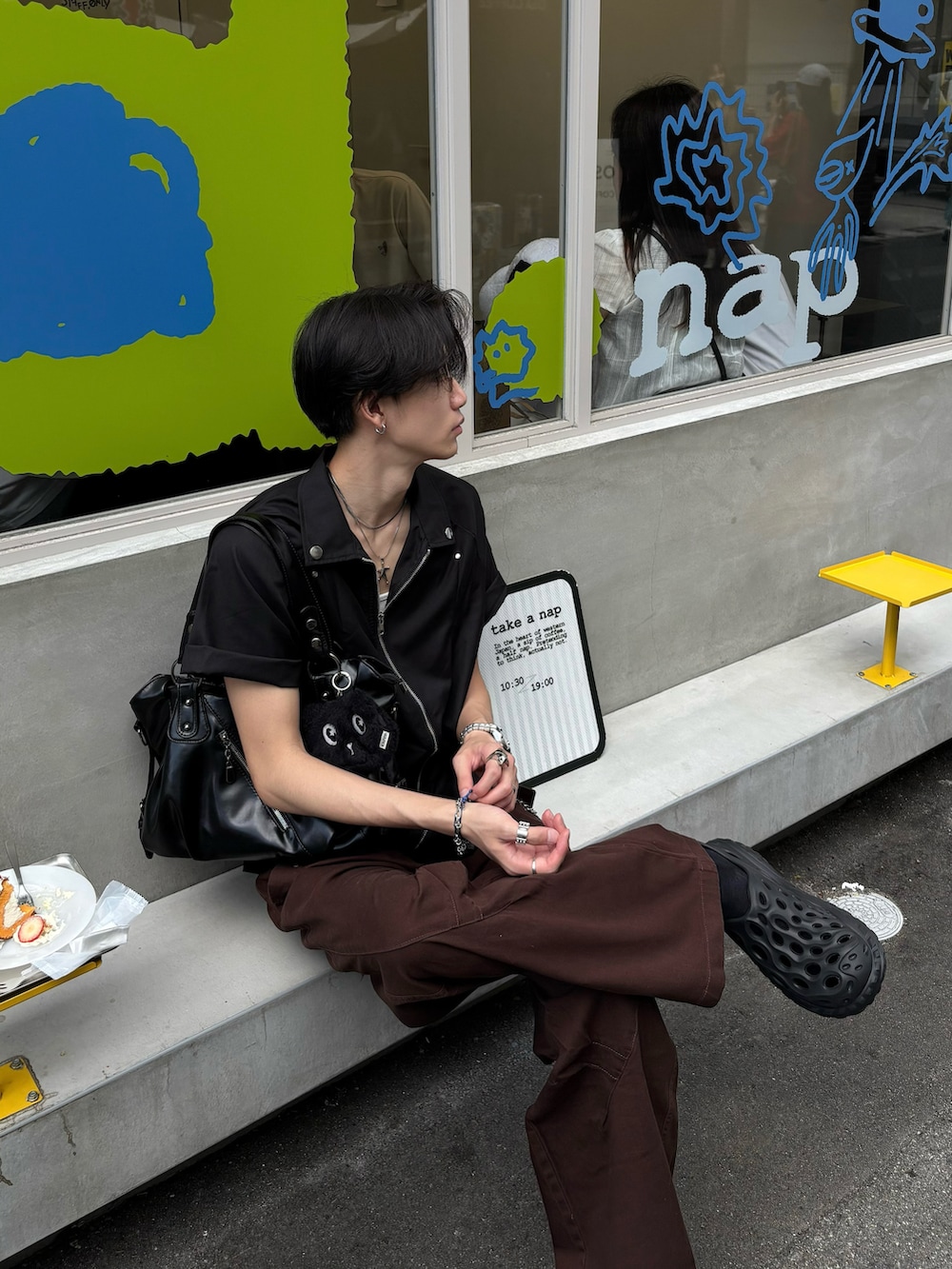 ブラック系のシャツ/ブラウス、ブラウン系のチノパンツ、ブラック系のサンダルを着用したメンズの春コーディネートの3枚目の写真